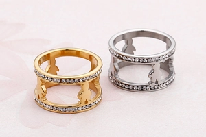 Detailed macro view of wide gold and silver rings with hollow figures and crystals