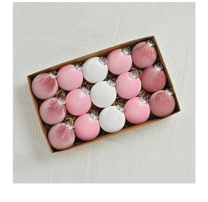 Detailed top view of 15 velvet pink and white Christmas ball ornaments in a kraft paper box