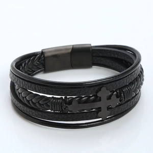 Detailed view of multilayer black leather bracelet with braided straps and metal cross