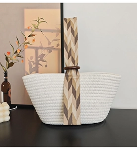 Detailed view of woven cotton rope handbag with wooden rings and herringbone handles
