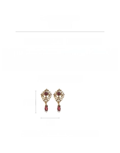 Macro shot of vintage gold earrings with heart-shaped ruby stones and rhinestone detail