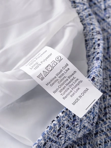 Close-up of the tweed jacket washing label showing 100 percent polyester composition