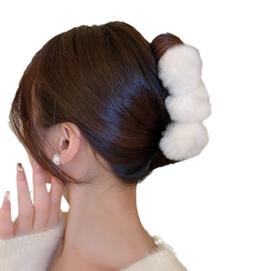 Elegant white faux fur pom-pom claw clip for women styled in a soft French twist bun
