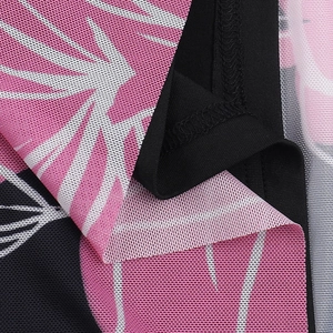 Close-up of ruched black mesh fabric with pink floral prints and fine stitching