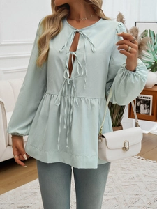 Detailed view of the mint green striped blouse with tie neck and lantern sleeves