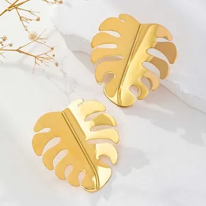 Polished 18K gold stainless steel monstera leaf drop earrings on a white background