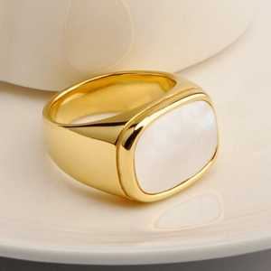 Minimalist square golden stainless steel ring with white shell inlay on ceramic plate