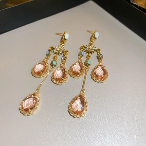 Macro detail of champagne crystal teardrop tassel earrings with intricate gold setting