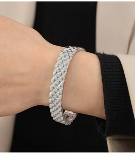 Close-up of a silver Jubilee style layered metal bracelet worn on a female wrist