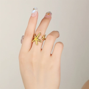 Detail of 18k gold starfish open ring with textured surface on model finger