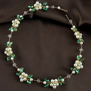 Detail of bridal hair vine with white pearls green leaves and crystals on silk