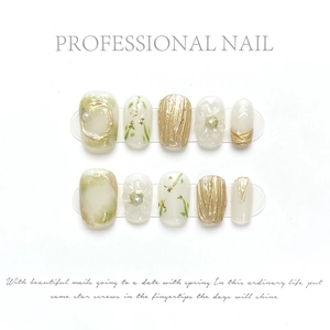 Detailed view of handmade press-on nails with marble texture, 3D flowers, and pearls