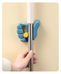 Detail of teal wall-mounted thumb mop holder with strong mechanical grip on clean wall