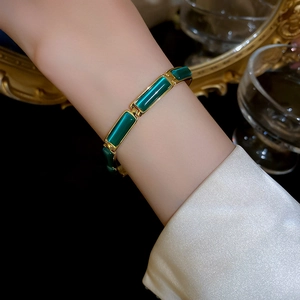 Close-up of a vintage gold plated bracelet with green opal stones on a female wrist