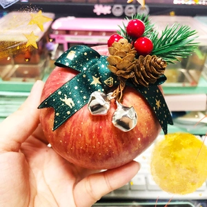 Christmas gift box apple with pine cone, silver bells and festive green star ribbon bow