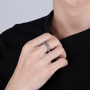 Detail of silver wavy titanium steel ring with vintage oxidized honeycomb texture on hand