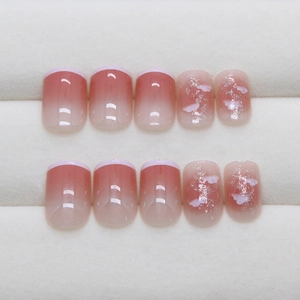 Pink blush gradient press-on nails with white French tips and silver glitter accents