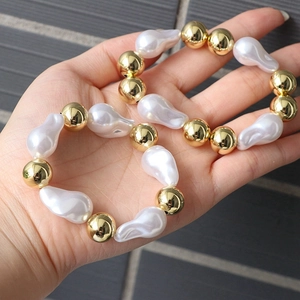 Macro view of baroque pearls and golden beads on an adjustable layered bracelet