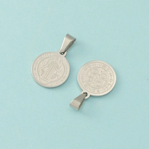 Macro detail of stainless steel Saint Benedict Medal pendants with embossed relief
