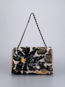 Detailed embroidery and sequins on black shoulder bag with woven texture and gold chain