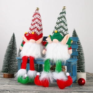 Close-up of Christmas gnomes with pointed hats and bells sitting on a blue wooden bench