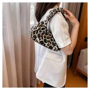 Side view of leopard print underarm bag with pleated shoulder strap on female model