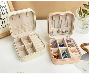 Close-up of portable jewelry box interior with necklace hooks and wave ring slots