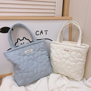 Quilted floral puffer tote bag in light blue and cream with a minimalist simple wish label