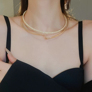 Close-up of double-layer choker with gold metal ring and creamy resin marble texture