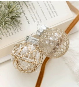 Close-up of elegant 6cm Christmas balls with gold glitter patterns on a festive tray