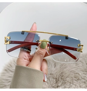 Detail of rimless blue gradient lenses with gold bridge and luxury wood grain temples