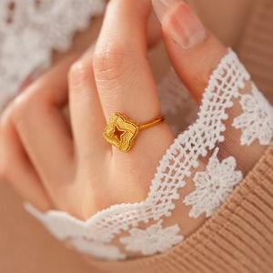 Gros plan d'une bague vintage plaquée or avec motif étoile et texture mate sur une main