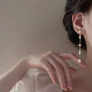 Detail of French vintage long tassel earrings with real freshwater pearls on a model