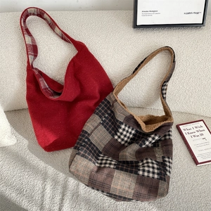 Detail of red and brown plaid tote bags with warm plush lining and wide shoulder straps