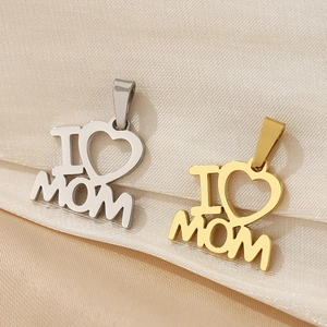 Detail of 18K gold and silver heart pendants with I Love Mom engraving on satin fabric