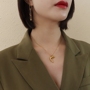 Elegant 18k gold plated stainless steel dolphin pendant necklace worn on a woman neck