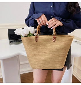 Close-up of woven tote bag featuring vintage bamboo handles and khaki straw texture