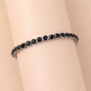 Detail of silver tennis bracelet with sparkling round black crystals on wrist