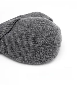 Macro detail of high-quality grey knit beanie showing reinforced top stitching and texture