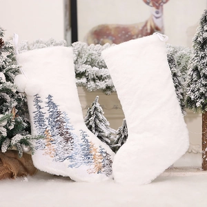White plush Christmas stockings with snowflake embroidery and pom-poms on a festive background