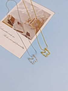 Detailed macro view of gold and silver hollow butterfly pendant necklaces with snake chains