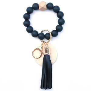 Detail of matte black silicone beads and wooden hexagon bead with leather tassel