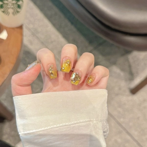 Luxurious cat-eye press-on nails with golden shimmer, 3D flowers, and geometric gems
