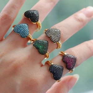 Close-up of model wearing six adjustable golden heart rings with colorful zircon stones