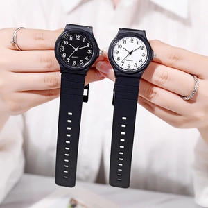 Detail view of quartz watches featuring black and white dials with leather straps