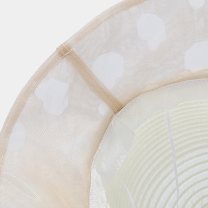 Detail of summer organza sun hat with white polka dots and woven straw texture