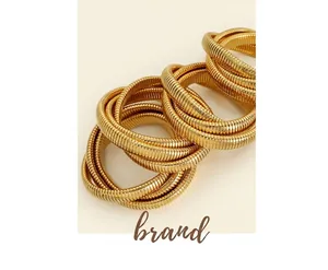 Macro detail of gold-plated triple-layer snake-bone coil bracelet with metallic texture