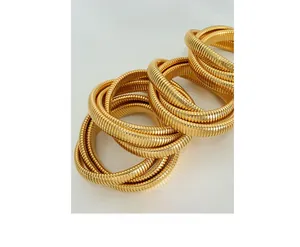 Macro detail of gold-plated triple-layer snake-bone coil bracelet with metallic texture