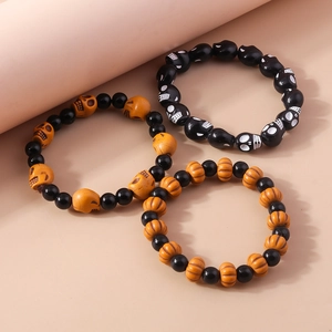 Detailed close-up of Halloween beaded bracelets with skull and pumpkin charms