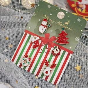 Vue détaillée du lot de 6 broches de Noël en émail sur un support de carte festif